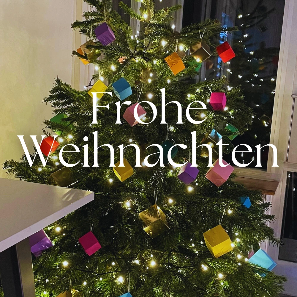 Weihnachtsbaum im Foyer von Ebro Color, dekoriert mit bunten Würfelschachteln